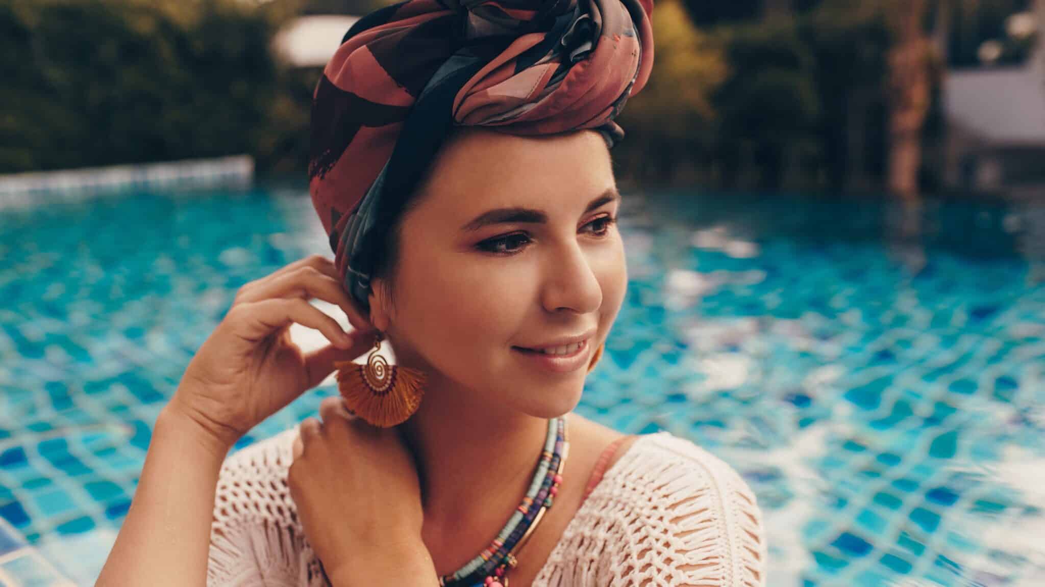 femme boucle oreille devant piscine edited scaled