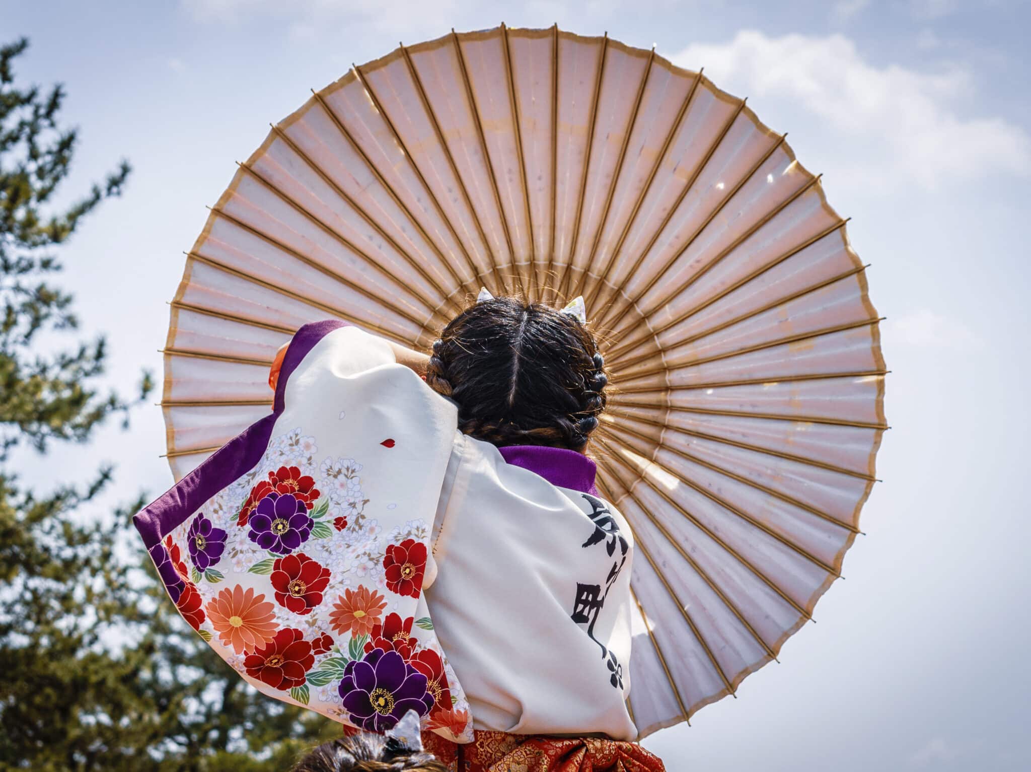 japonaise de dos en kimono avec grande ombrelle claire