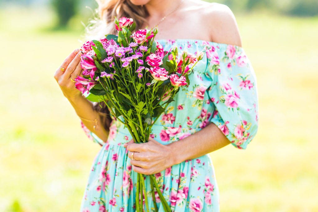 femme dans un champ avec une robe à fleur